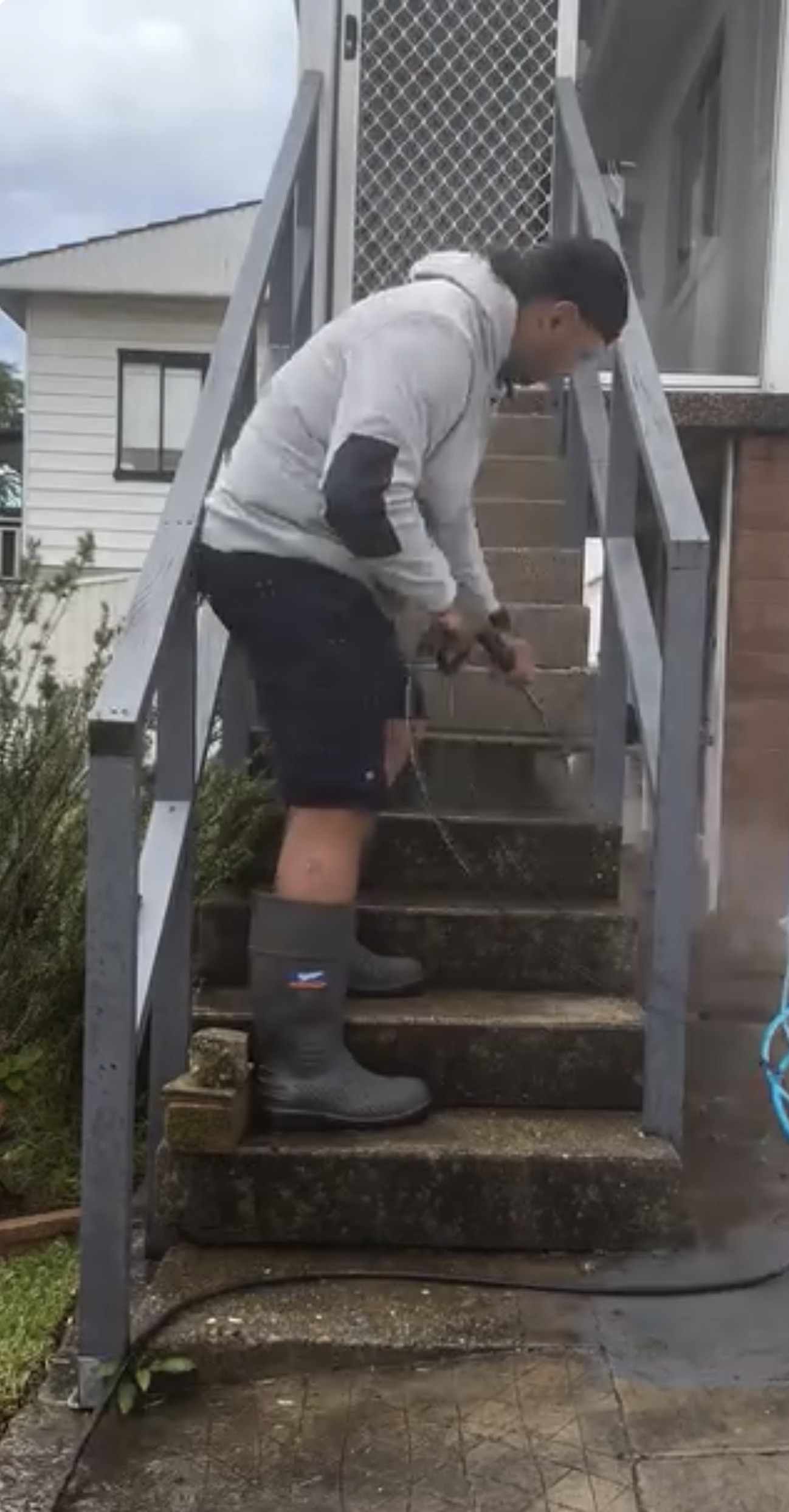 BVC crew member pressure washing a set of concrete steps